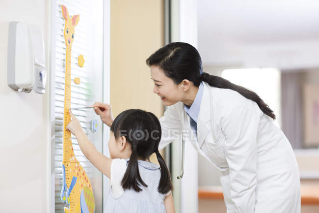 Médico chinês medir altura da menina — Fotografia de Stock