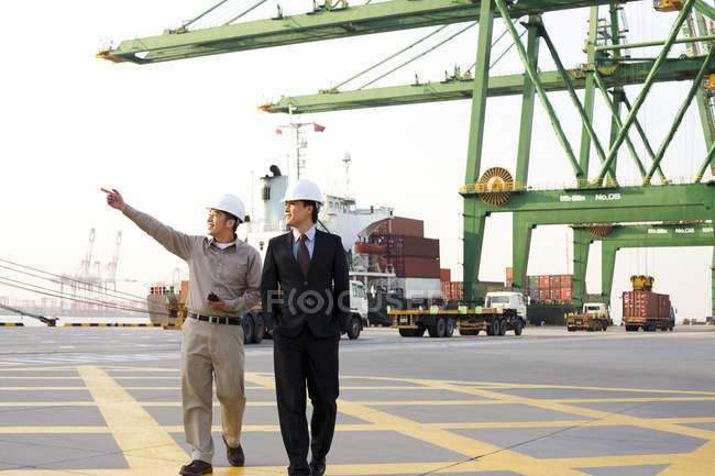 Operaio del settore marittimo cinese che mostra porto a uomo d'affari — Foto stock