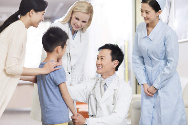 Médicos chinos hablando con un chico en el hospital - foto de stock