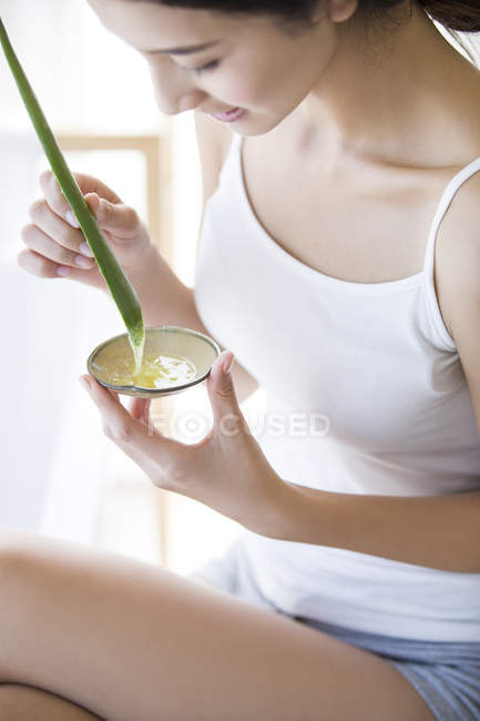 Mujer china mezclando cosméticos naturales de aloe vera - foto de stock