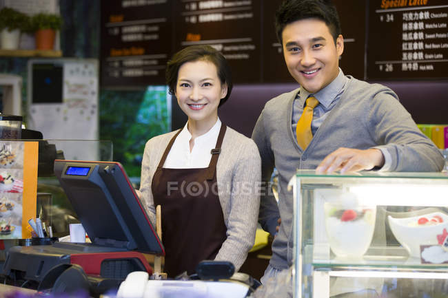 Портрет владельца китайской кофейни и официантки у стойки — стоковое фото