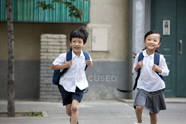 Chinese children running from school building — Stock Photo