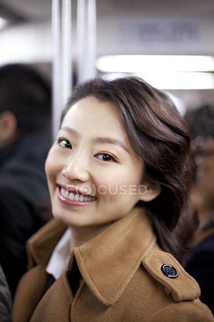 Cheerful Chinese woman in subway train — Stock Photo