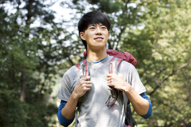 Chinese male hiker looking away in woods — Stock Photo