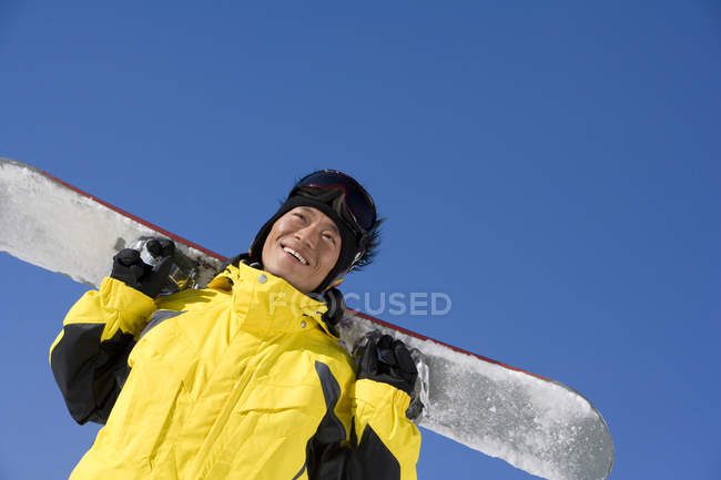 Китаец позирует со сноубордом — стоковое фото
