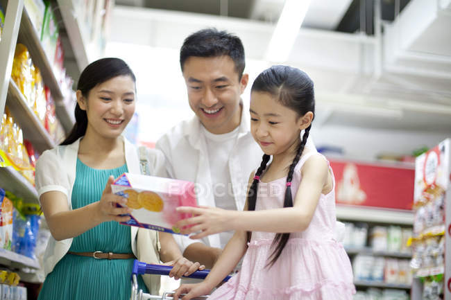 Chinese family choosing cookies in supermarket — Stock Photo