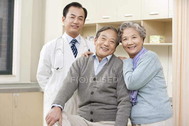 Senior Chinese couple in examination room with mature doctor — Stock Photo