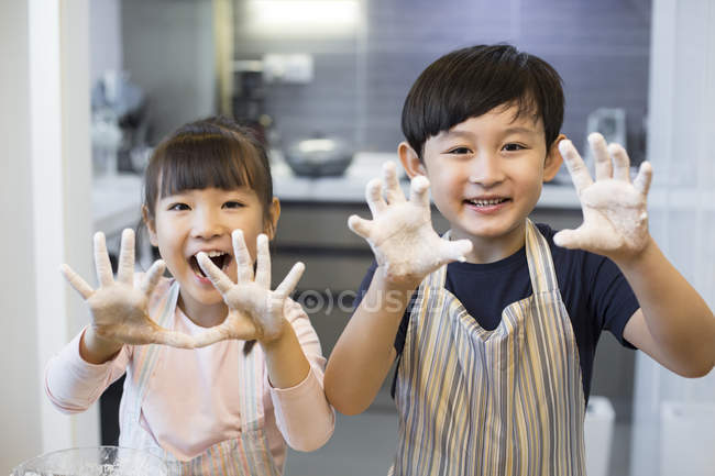 Chinese siblings playing with flour — Stock Photo