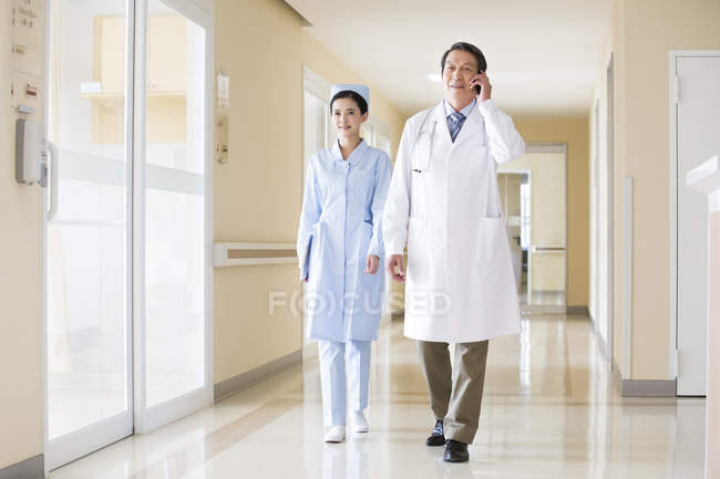 Trabajadores médicos chinos caminando por el pasillo - foto de stock