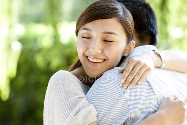 Giovane donna cinese abbracciare fidanzato nel parco — Foto stock