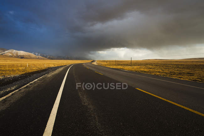 Highway under dramatic sky in Qinghai province — Stock Photo