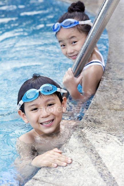 Crianças chinesas em óculos de natação à beira da piscina — Fotografia de Stock