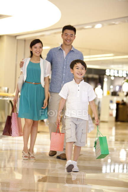 Familia china con hijo de compras en grandes almacenes - foto de stock