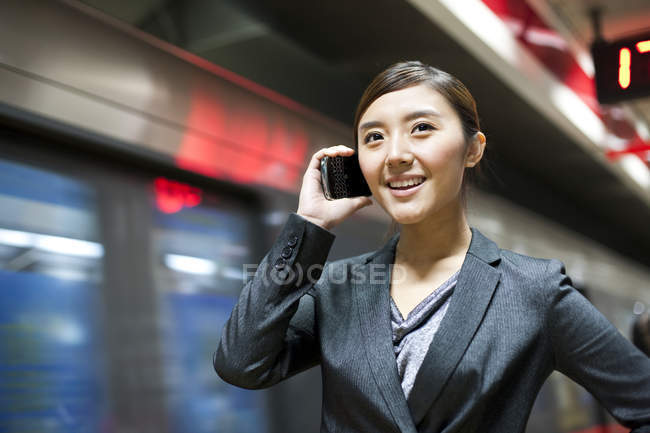 Empresária chinesa falando ao telefone na estação de metrô — Fotografia de Stock