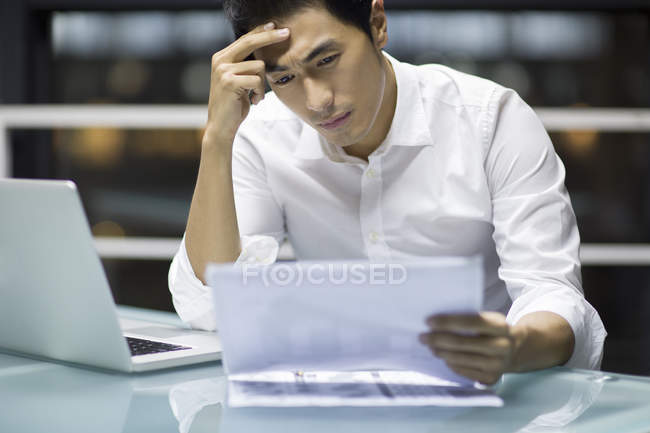 Cansado empresário chinês segurando documentos no escritório — Fotografia de Stock