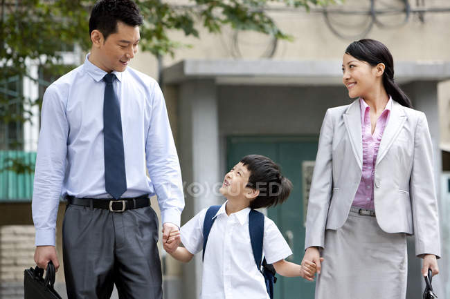 Écolier chinois marchant avec les parents dans la rue — Photo de stock