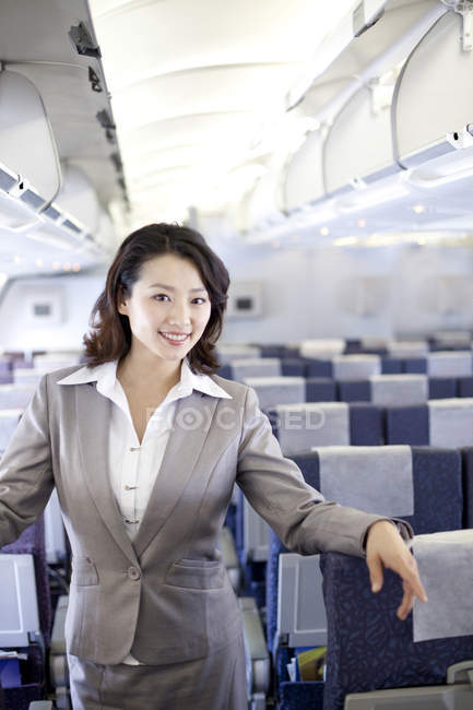 Chinesische Geschäftsfrau posiert im Flugzeug — Stockfoto