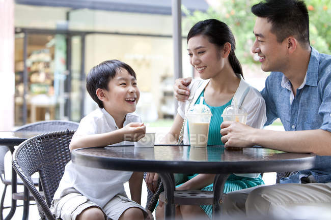 Genitori cinesi con figlio godendo di bevande fredde e gelato al caffè marciapiede — Foto stock