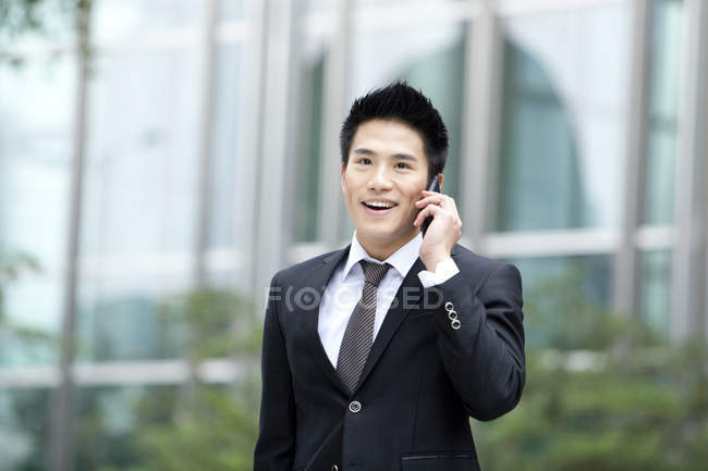Китайский бизнесмен разговаривает по телефону в городе — стоковое фото