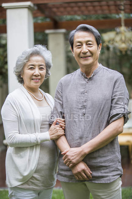 Веселая старшая китайская пара, стоящая на улице — стоковое фото