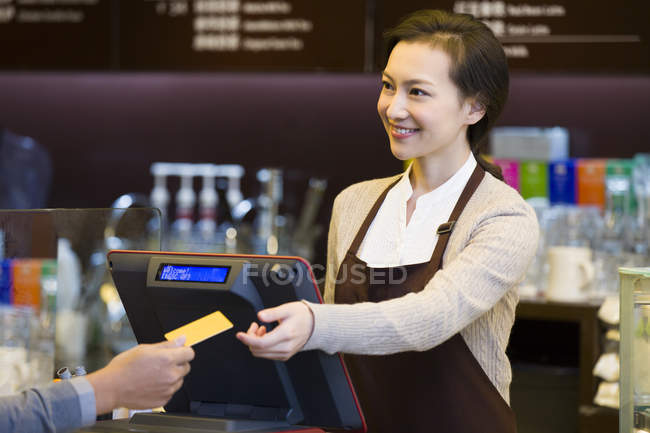 Cliente maschio che paga con carta di credito in caffetteria — Foto stock