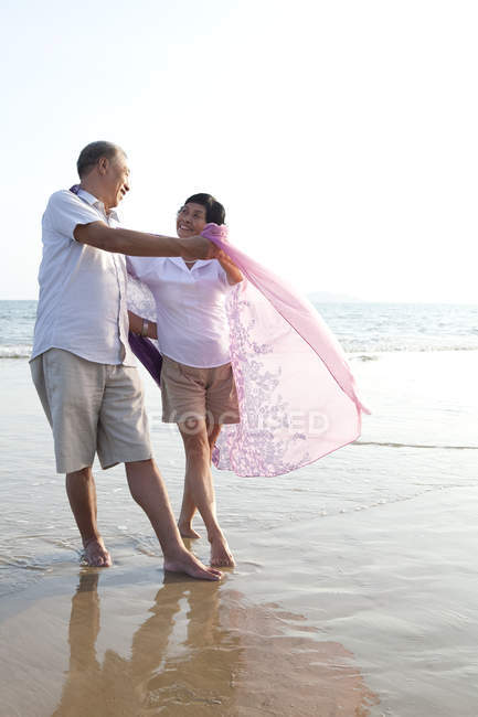 Casal chinês sênior dançando na praia — Fotografia de Stock