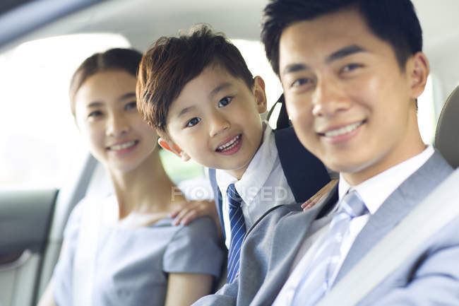 Casal chinês com filho montando no carro juntos — Fotografia de Stock