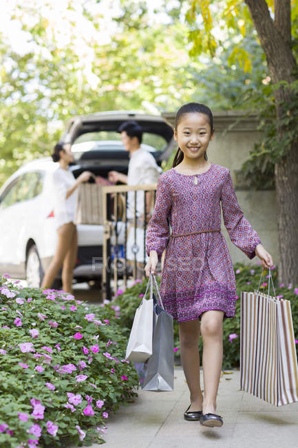 Chinesisches Mädchen mit Einkaufstüten spaziert in Hof — Stockfoto