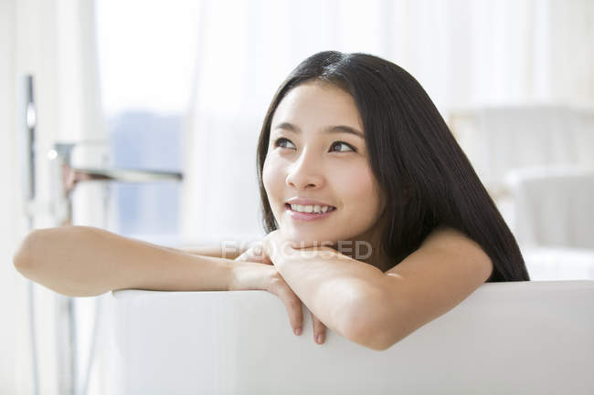 Китайська жінка, що лежав у ванну і дивитися вбік — стокове фото