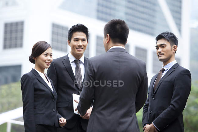 Chinese working team discussing business on street — Stock Photo
