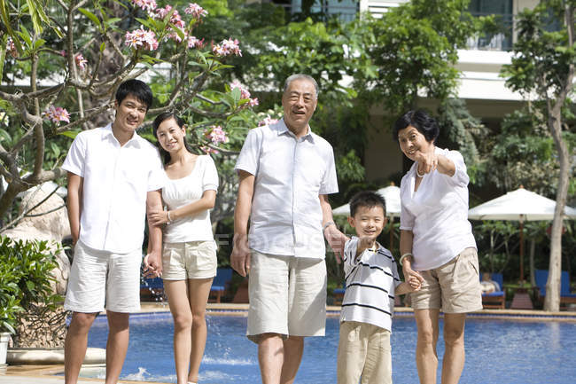 Família chinesa com menino de pé e apontando para resort turístico — Fotografia de Stock
