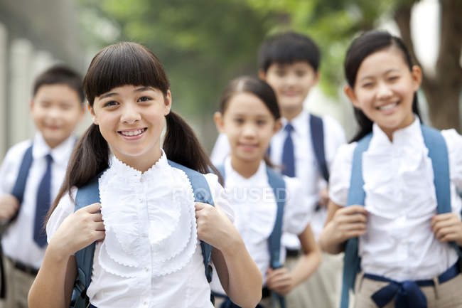 Scolari cinesi in uniforme scolastica in posa sulla strada — Foto stock
