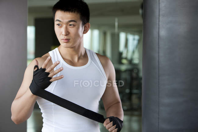Chinese man putting on hand wrap — Stock Photo