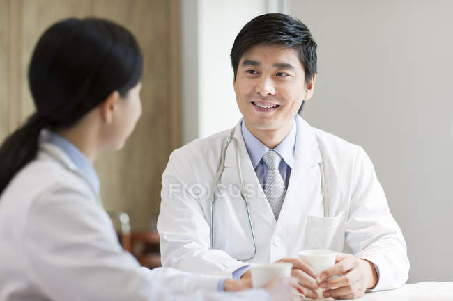 Chinese doctors talking with coffee in hospital — Stock Photo
