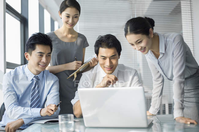 Les gens d'affaires chinois utilisant un ordinateur portable dans le bureau — Photo de stock