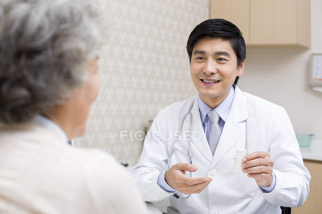 Chinesischer Arzt erklärt Patientin Medikamentendosis — Stockfoto