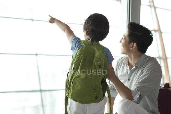 Chinês pai e filho apontando para a vista no aeroporto — Fotografia de Stock