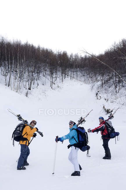 Three Chinese skiers hiking in snow-capped mountains — Stock Photo