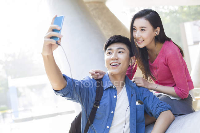 Chinese couple taking selfie on street — Stock Photo