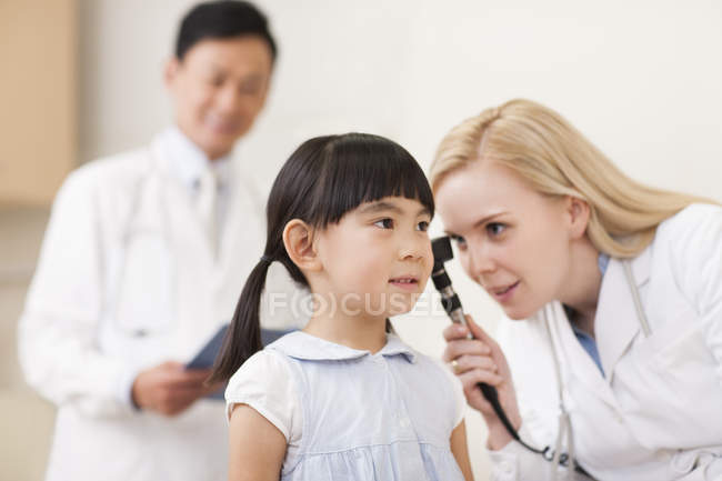 Лікарі вивчають вухо дівчини в лікарні — стокове фото