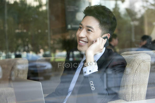 Китайський бізнесмен, розмовляємо по телефону в кафе — стокове фото