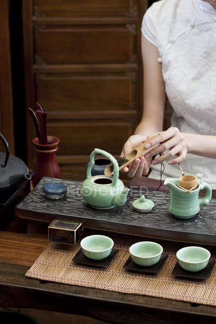 Woman in traditional cheongsam performing tea ceremony — Stock Photo