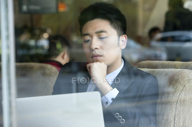 Empresário chinês usando laptop no café — Fotografia de Stock