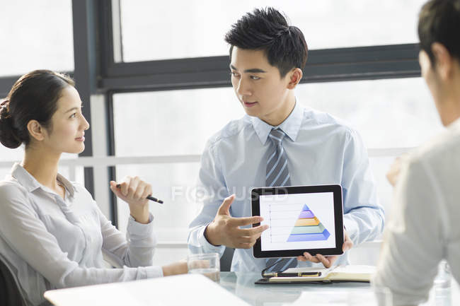 Chinese business people using digital tablet in office — Stock Photo