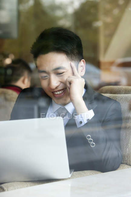 Empresário chinês usando laptop no café — Fotografia de Stock