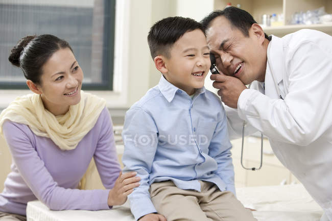 Chinesisch reif arzt untersuchung junge mit mutter im krankenhaus — Stockfoto