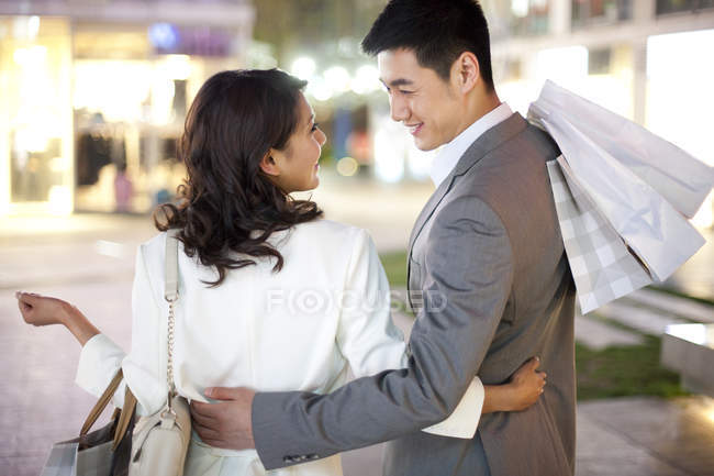 Visão traseira do casal chinês nas compras na cidade — Fotografia de Stock