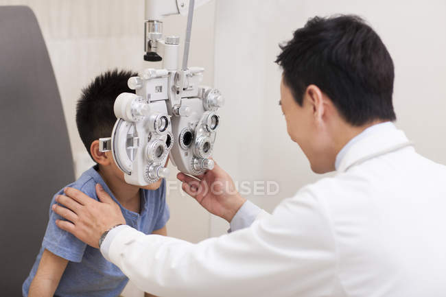 Chino chico recibiendo ojos examen - foto de stock