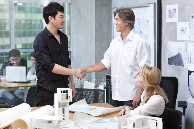 Arquitetos masculinos apertando as mãos no escritório — Fotografia de Stock