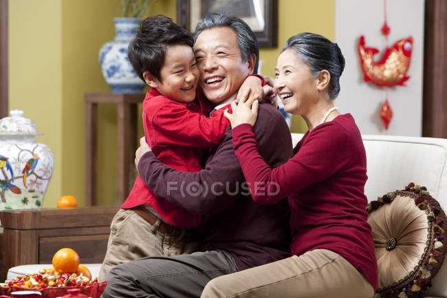 Grandparents hugging grandson during Chinese New Year — Stock Photo